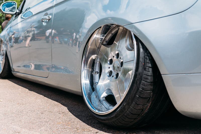 Kundenspezifisches abgestimmtes Sportwagenrad des Lowrider mit kleinem Gummireifen und großer Scheibe stockbilder Kundenspezifisches abgestimmtes Sportwagenrad des Lowrider mit kleinem Gummireifen und großer Scheibe stockbilder
