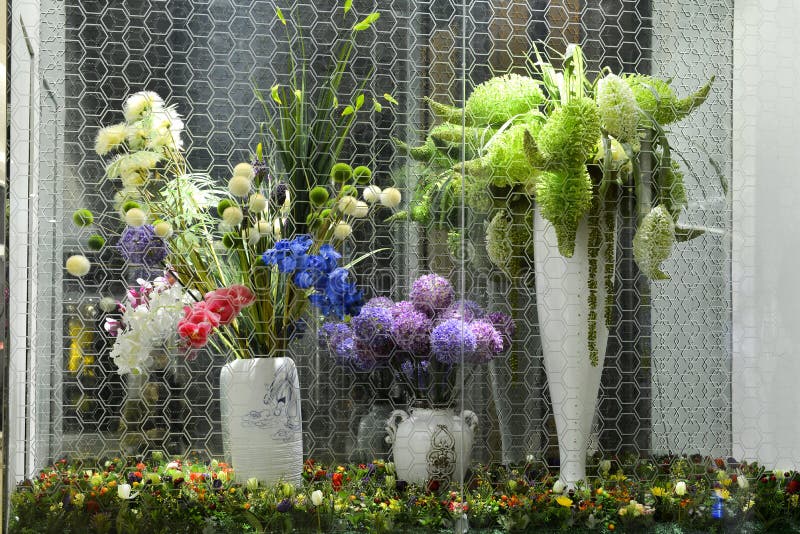 Kunstbloemen en -planten in een glazen kast stock fotografie