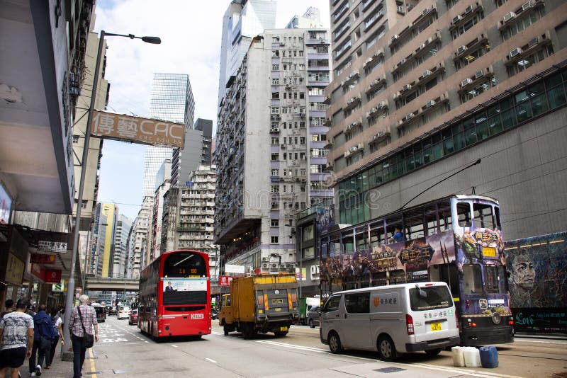Kupczy drogę z retro tramwajem i chińczykami chodzi obok drogi przy Bladą Chai drogą w Hong Kong, Chiny. Ruch drogowy droga z retro tramwajem i chińczycy chodzi obok drogi przy Bladą Chai drogą między centralą iść drogiej na grobli zatoka na Wrześniu 3, 2018 w Hong Kong, Chiny