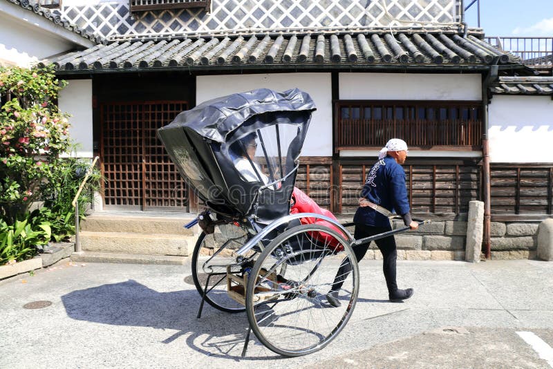 KURASHIKI, GIAPPONE - 31 marzo 2019: Risciò sulla via medievale immagine stock libera da diritti KURASHIKI, GIAPPONE - 31 marzo 2019: Risciò sulla via medievale immagine stock libera da diritti