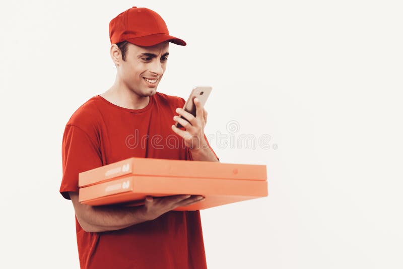 Kurir med asken i orange enhetliga blickar i telefon arkivbilder Kurir med asken i orange enhetliga blickar i telefon arkivbilder