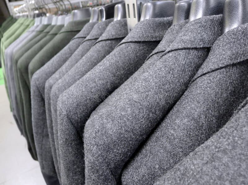 A row of elegant jackets hanged and displayed in a clothes shop. A row of elegant jackets hanged and displayed in a clothes shop.