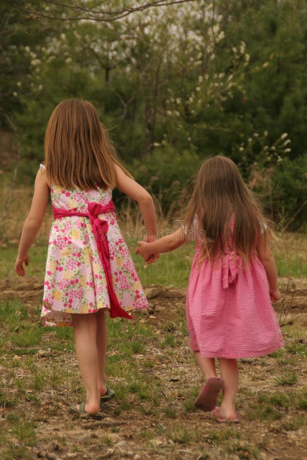 Little girls holding hands walking. Little girls holding hands walking