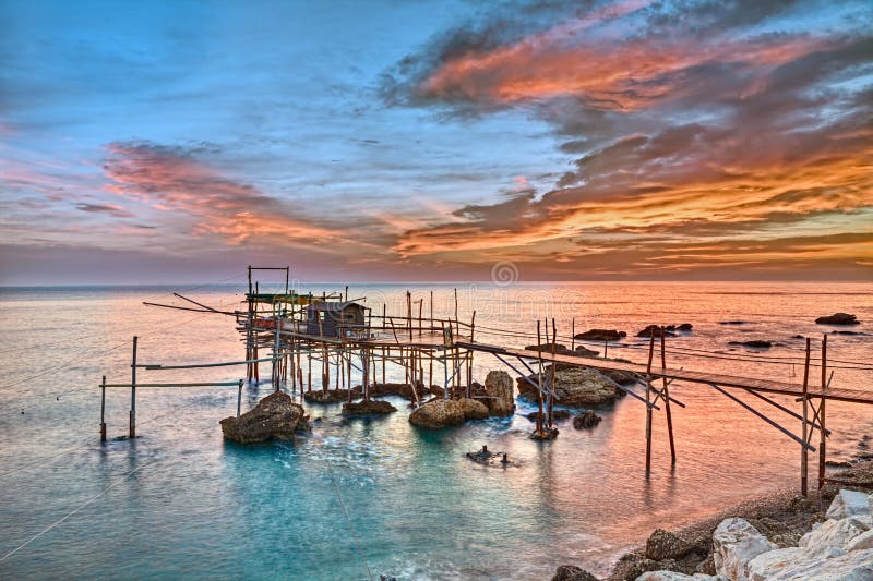 Old fishing hut trabocco, the typical wooden palafitte in the sunrise of the Mediterranean sea coast in Chieti, Abruzzo, Italy. Old fishing hut trabocco, the typical wooden palafitte in the sunrise of the Mediterranean sea coast in Chieti, Abruzzo, Italy