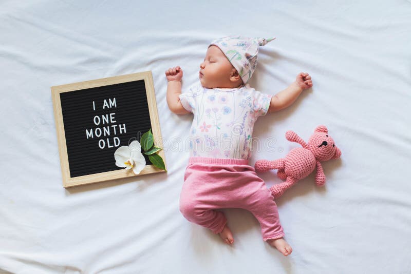 Kute een maand oude baby girl in het driehoekige uitlegwerk tussen brievenbus en teddy beer. Eén maand aankondiging royalty-vrije stock afbeelding Kute een maand oude baby girl in het driehoekige uitlegwerk tussen brievenbus en teddy beer. Eén maand aankondiging royalty-vrije stock afbeelding