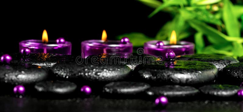 Kuuroordstilleven van de stenen van het zenbasalt met dalingen, lilac kaarsen, B stock fotografie Kuuroordstilleven van de stenen van het zenbasalt met dalingen, lilac kaarsen, B stock fotografie