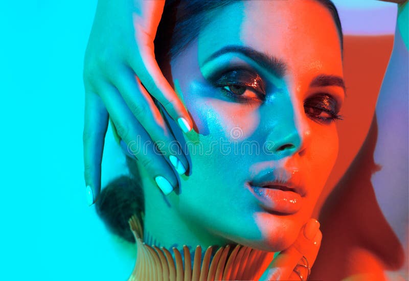 Kvinna för modemodell i färgrika ljusa ljus med moderiktig makeup som poserar i studio royaltyfri bild