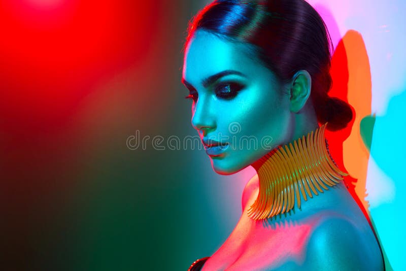 Fashion model woman in colorful bright lights posing. Portrait of beautiful girl with trendy makeup. Fashion model woman in colorful bright lights posing. Portrait of beautiful girl with trendy makeup