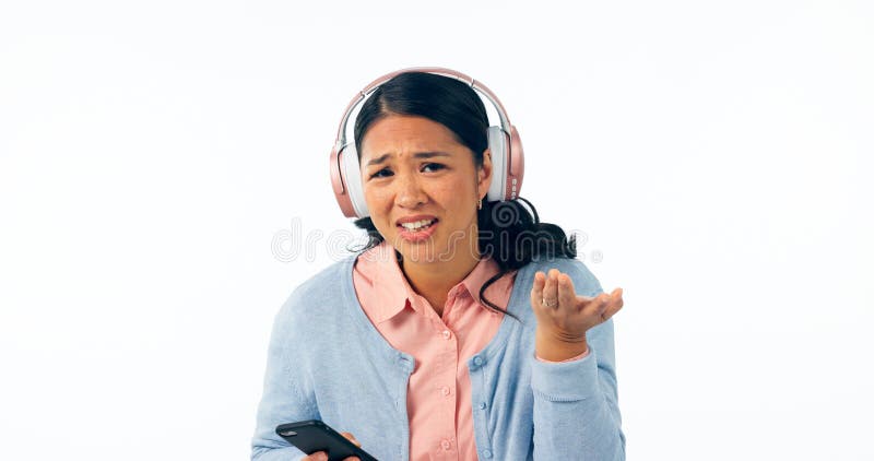 Kvinna förvirrad och smartphone i porträtt i hörlurar musik och direktuppspelning i fråga i studio mockup. ung royaltyfri foto
