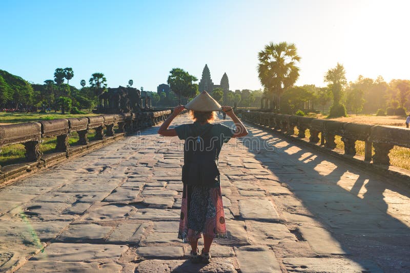 Kvinna i den Bayon templet som ser stenframsidor, Angkor Thom, klar bl? himmel f?r morgonljus Buddismmeditationbegrepp, ber?md v? royaltyfria foton Kvinna i den Bayon templet som ser stenframsidor, Angkor Thom, klar bl? himmel f?r morgonljus Buddismmeditationbegrepp, ber?md v? royaltyfria foton