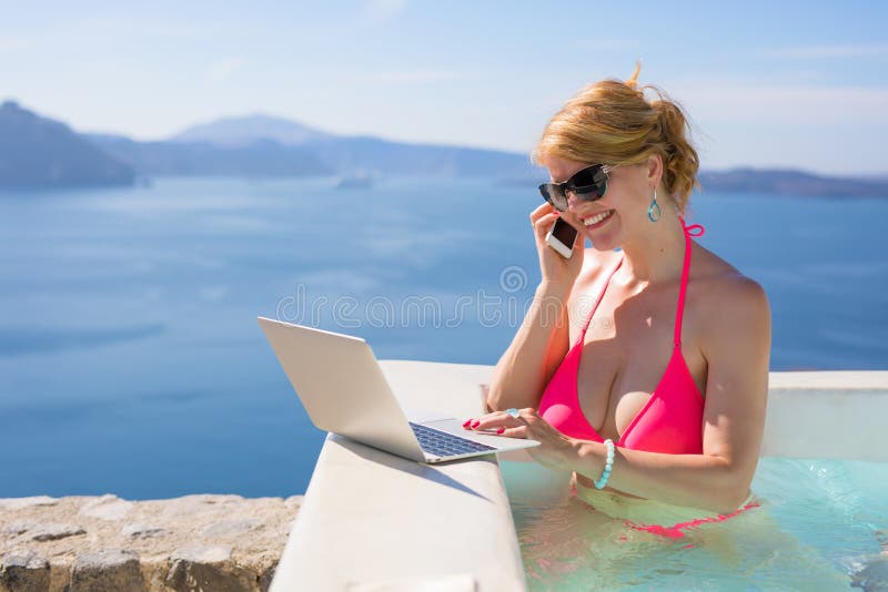 Kvinna i den rosa bikinin som arbetar på bärbara datorn och talar på mobiltelefonen arkivbilder Kvinna i den rosa bikinin som arbetar på bärbara datorn och talar på mobiltelefonen arkivbilder