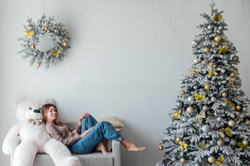 Kvinna i det dekorerade julgranen med leksaksljus i presenter för nya år fotografering för bildbyråer