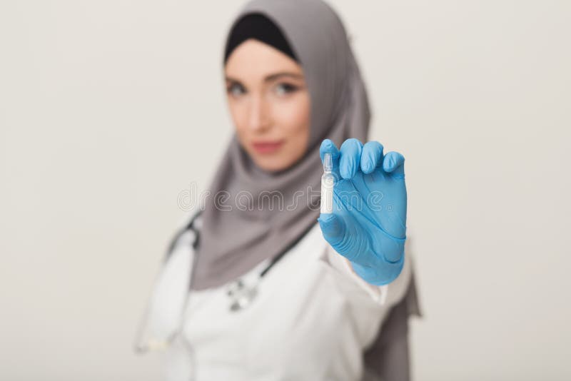 Kvinna i hijabvisningampule på studiobakgrund arkivbilder Kvinna i hijabvisningampule på studiobakgrund arkivbilder