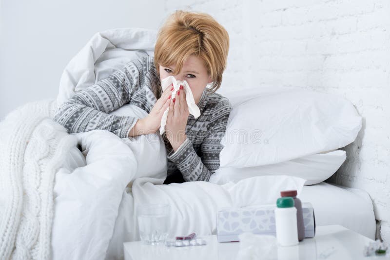 kvinna med att nysa näsan som blåser i silkespapper på tecken för virus för influensa för sänglidande som kalla har medicinminnes