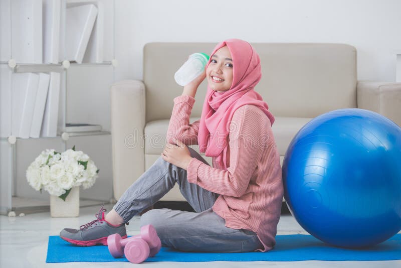 Kvinna med hijab som hemma gör övning royaltyfri foto Kvinna med hijab som hemma gör övning royaltyfri foto