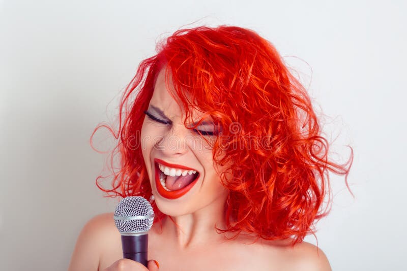 Woman with Microphone. Female funny singer screaming on mic portrait close up isolated white gray background with copy space. Woman with Microphone. Female funny singer screaming on mic portrait close up isolated white gray background with copy space