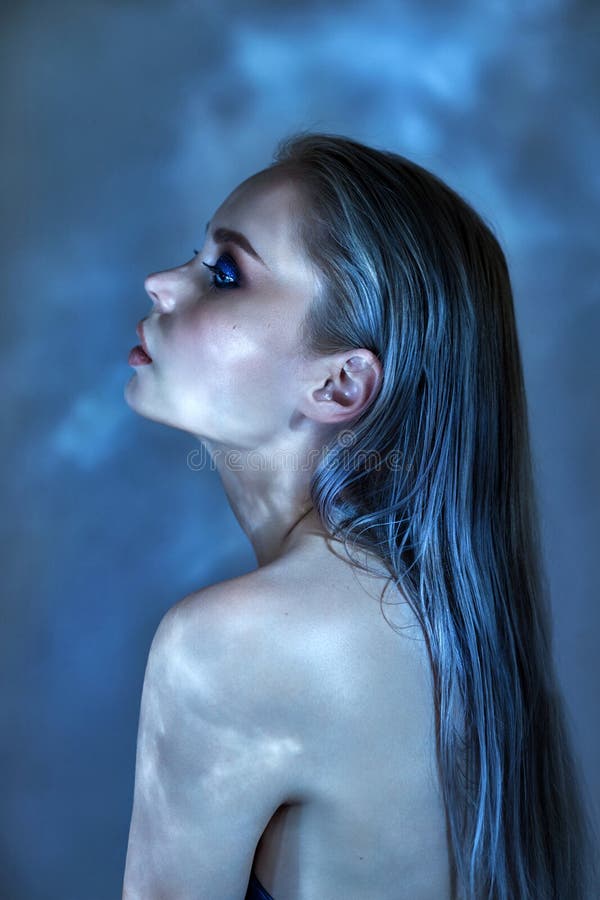 Woman with wet hair and bright makeup posing near the water, portrait. Glare from the water on the girl face, cosmetics to moisturize the skin, Spa. Woman sitting by blue pool. Art makeup on the face. Woman with wet hair and bright makeup posing near the water, portrait. Glare from the water on the girl face, cosmetics to moisturize the skin, Spa. Woman sitting by blue pool. Art makeup on the face