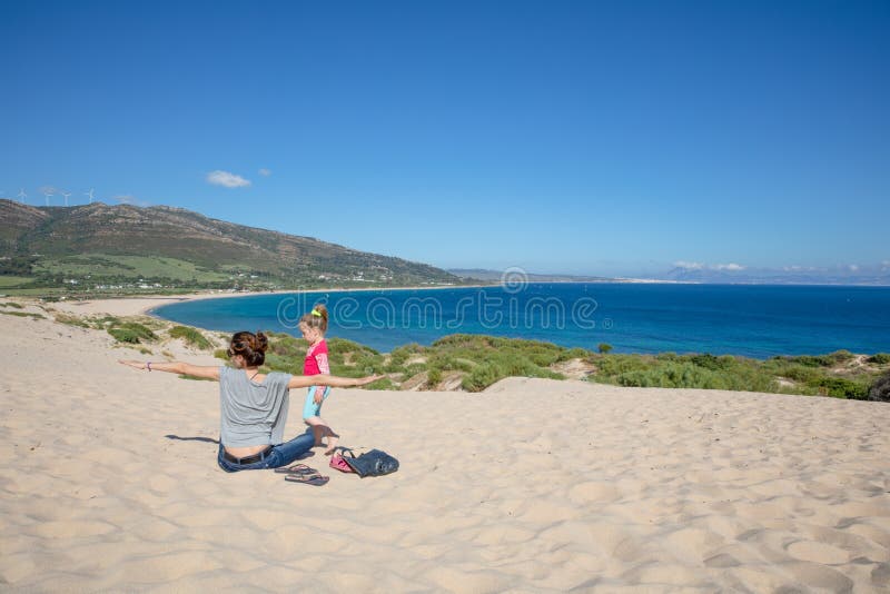 Kvinna med öppna armar och flicka ovanpå valdevaqueros dune fotografering för bildbyråer