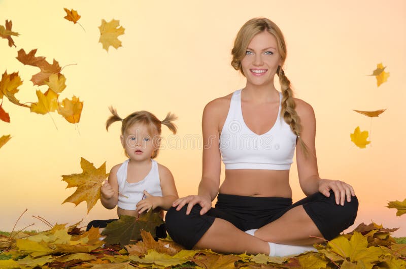 Kvinna och barn som gör yoga under sidorna royaltyfri bild Kvinna och barn som gör yoga under sidorna royaltyfri bild