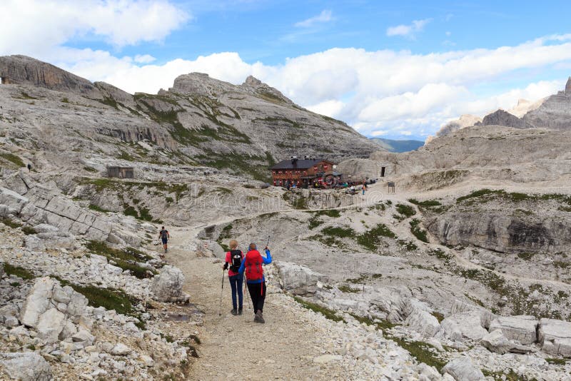 Kvinna och flicka som fotvandrar in mot den alpina kojan Bullelejochhutte i Sexten Dolomites, södra Tyrol arkivbilder Kvinna och flicka som fotvandrar in mot den alpina kojan Bullelejochhutte i Sexten Dolomites, södra Tyrol arkivbilder