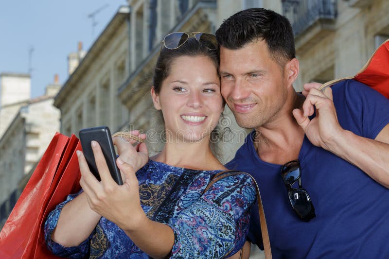 Kvinna och man som tar sig självt efter att ha shoppat tillsammans royaltyfri bild