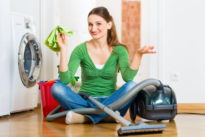 Young woman cleaning at home, she has a cleaning day and using a vacuum cleaner cleaning products and a bucket. Young woman cleaning at home, she has a cleaning day and using a vacuum cleaner cleaning products and a bucket
