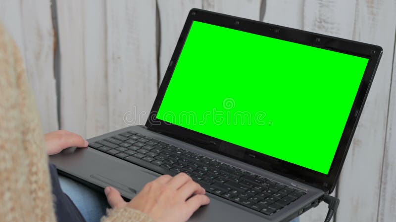 Kvinna som använder bärbara datorn med den gröna skärmen