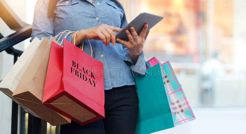Kvinna som använder påsen för minnestavla- och innehavBlack Friday shopping royaltyfria bilder