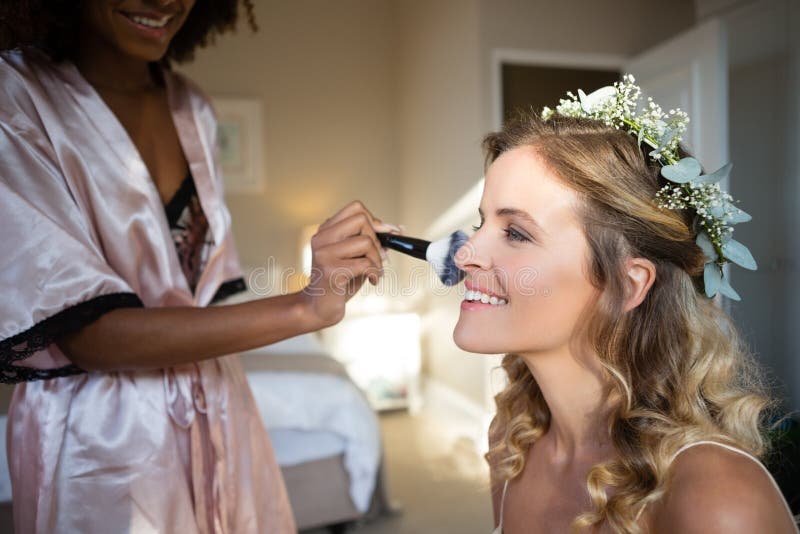 Kvinna som applicerar makeup till bruden i loge arkivbild Kvinna som applicerar makeup till bruden i loge arkivbild