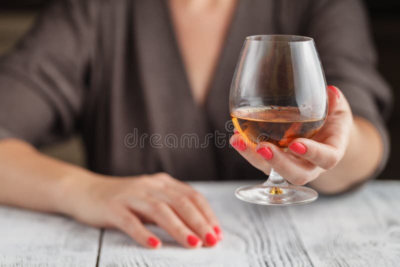Kvinna som dricker alkohol på mörk bakgrund Fokus på vinexponeringsglas