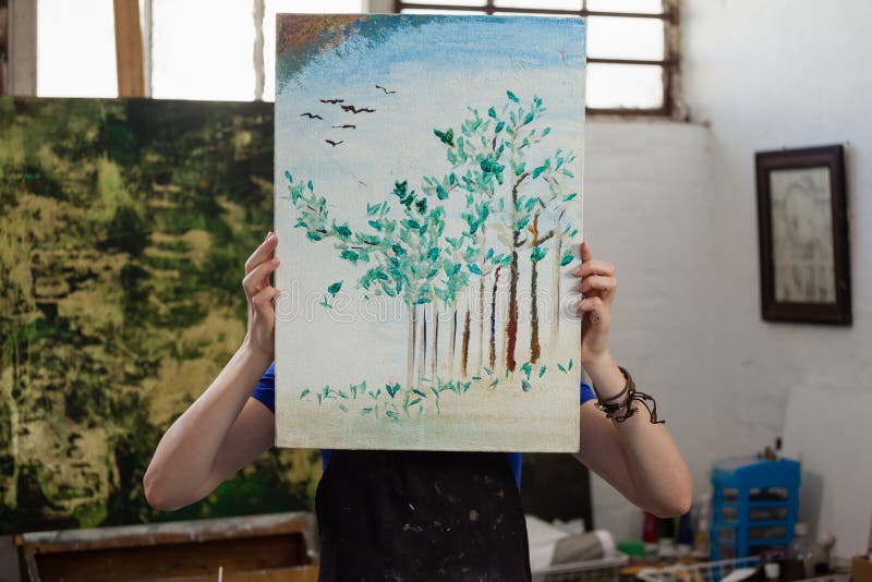 Kvinna som döljer hennes framsida bak målning arkivfoto Kvinna som döljer hennes framsida bak målning arkivfoto