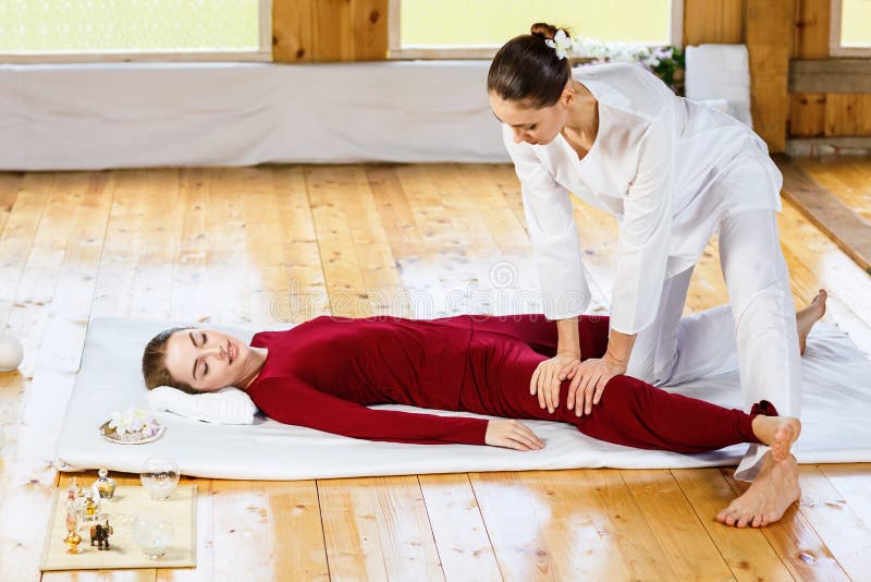 Kvinna som får traditionell thai sträckande massage av terapeuten royaltyfri bild Kvinna som får traditionell thai sträckande massage av terapeuten royaltyfri bild