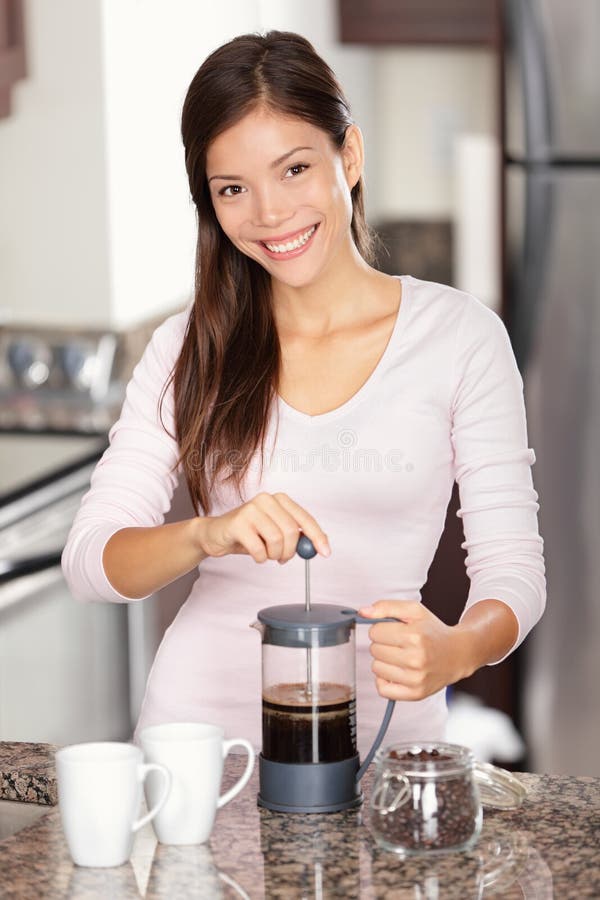 Kvinna som gör kaffe i kök arkivfoto