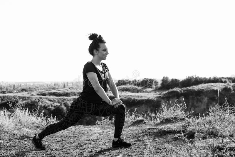 Kvinna som gör sporten som är utomhus- i aftontid som är svartvit arkivfoto Kvinna som gör sporten som är utomhus- i aftontid som är svartvit arkivfoto