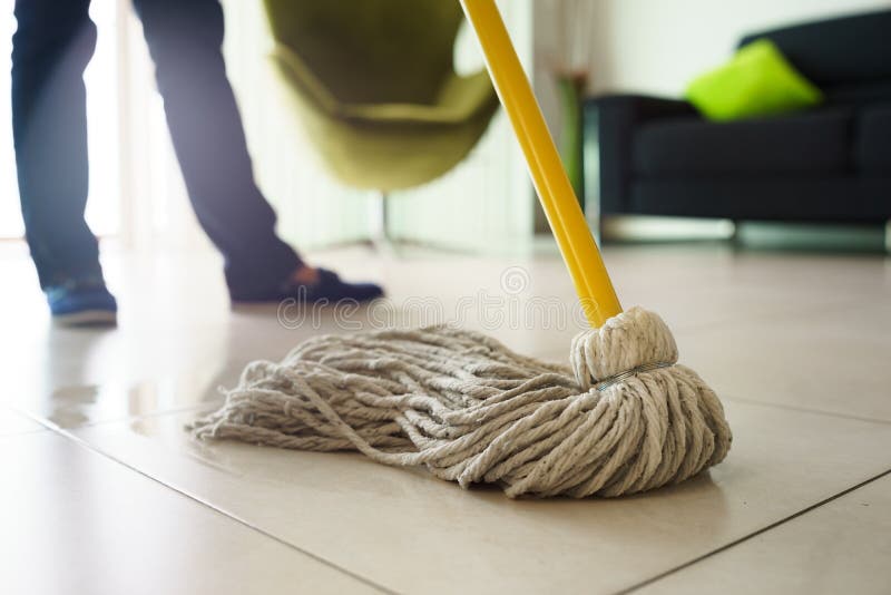 Woman at home, doing chores and housekeeping, wiping floor with water in living room. Focus on floor and mop. Woman at home, doing chores and housekeeping, wiping floor with water in living room. Focus on floor and mop