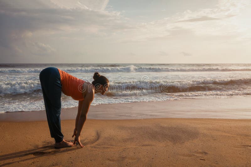 Kvinna som gör yogasolhälsningen Surya Namaskar på stranden royaltyfri bild Kvinna som gör yogasolhälsningen Surya Namaskar på stranden royaltyfri bild