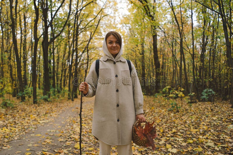 Kvinna som har höstpromenader i skogen royaltyfria bilder