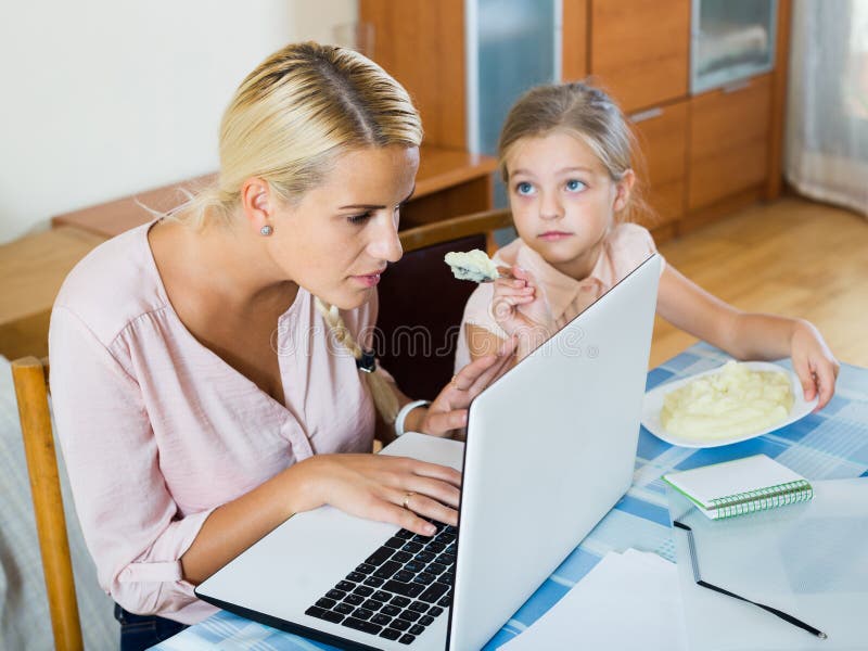 Kvinna som hemifrån arbetar, liten dotter som frågar för uppmärksamhet arkivbilder Kvinna som hemifrån arbetar, liten dotter som frågar för uppmärksamhet arkivbilder