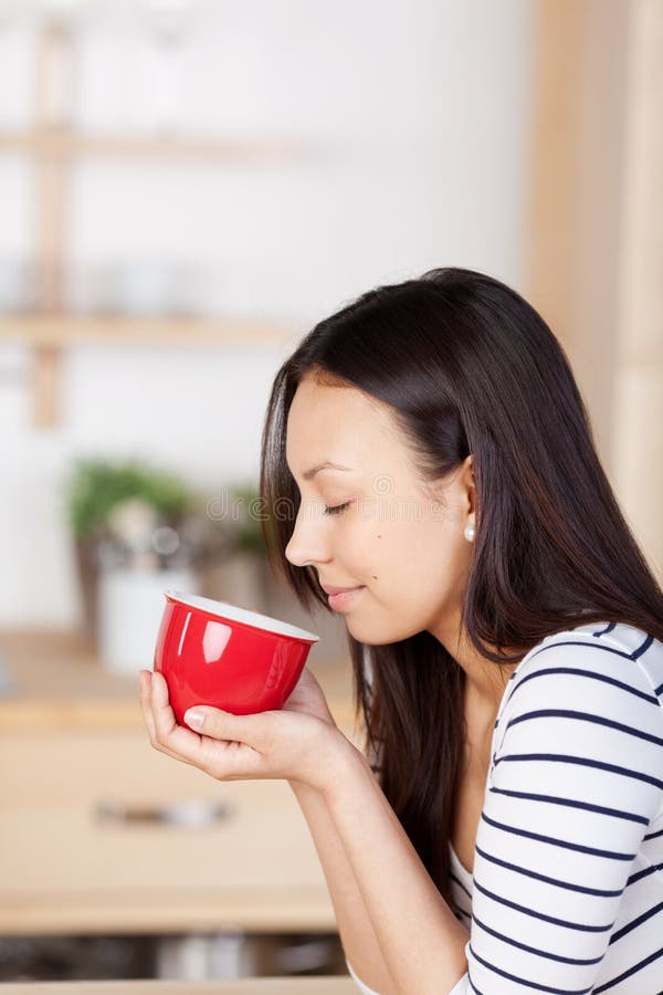 Kvinna som hemma tycker om aromen av kaffe