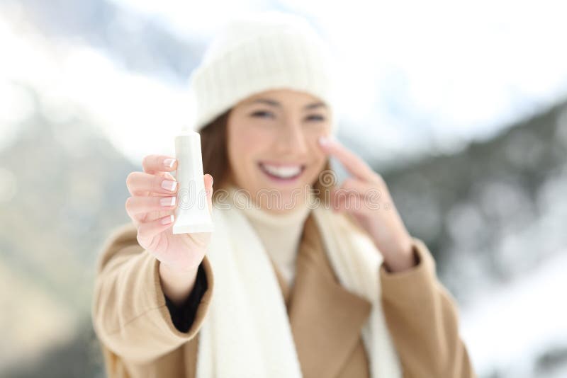 Kvinna som hydratiserar ansikts- hud och visar produkten royaltyfri foto Kvinna som hydratiserar ansikts- hud och visar produkten royaltyfri foto