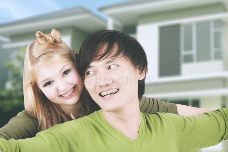 Kvinna som omfamnar hennes make nära deras hus arkivfoton Kvinna som omfamnar hennes make nära deras hus arkivfoton