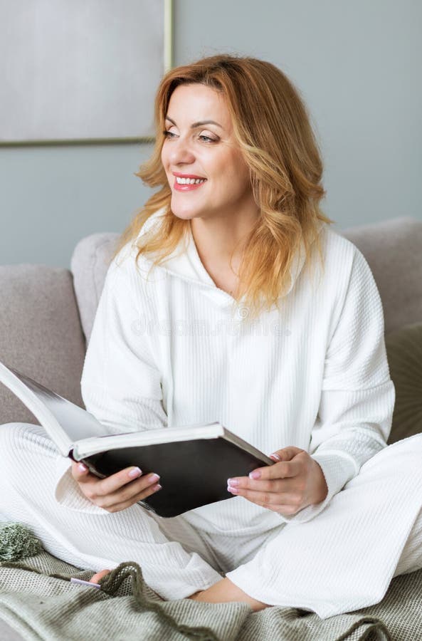 Woman sitting on couch and reading book. Social media detox. Slow living lifestyle. Mental wellbeing on quarantine. Happy female enjoying literature. Calm bookworm spending day off gadgets. Woman sitting on couch and reading book. Social media detox. Slow living lifestyle. Mental wellbeing on quarantine. Happy female enjoying literature. Calm bookworm spending day off gadgets