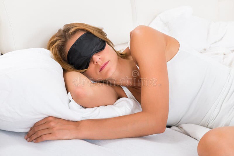 Young Woman Sleeping With Sleep Mask In Bed. Young Woman Sleeping With Sleep Mask In Bed
