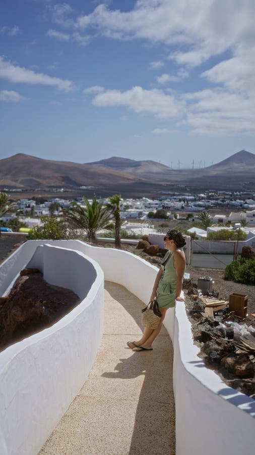 Kvinna som står utomhus i lagomar lanzarote och som njuter av det scenmässiga kanariska ölandskapet med berg i bakgrunden och royaltyfri foto