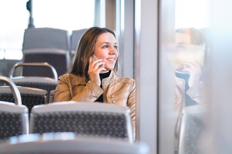 Kvinna som talar på telefonen, medan rida bussen, drevet eller tunnelbanan arkivbilder Kvinna som talar på telefonen, medan rida bussen, drevet eller tunnelbanan arkivbilder