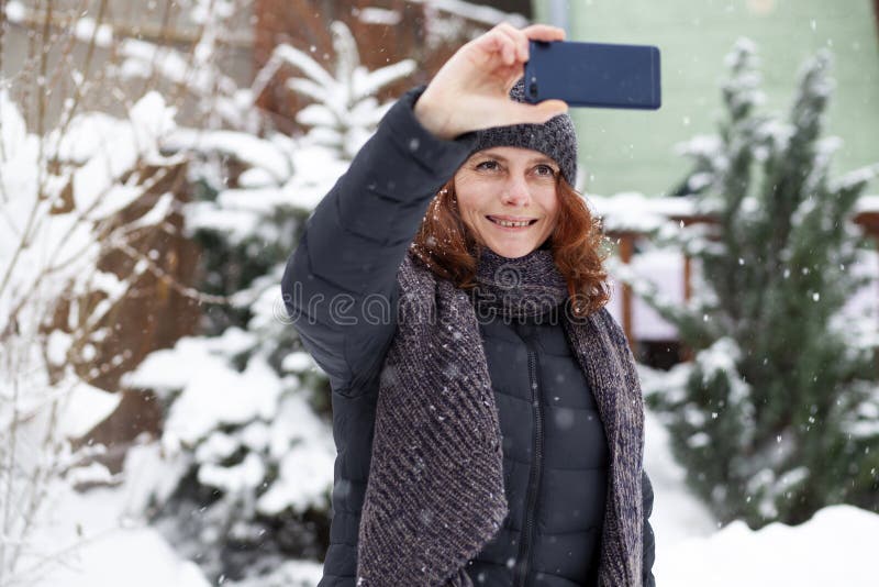 kvinna som tar en selfie i snö royaltyfria bilder kvinna som tar en selfie i snö royaltyfria bilder