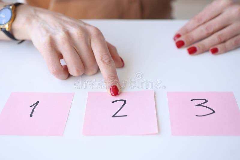 Woman showing index finger to sticker with number 2. Real life lottery concept. Woman showing index finger to sticker with number 2. Real life lottery concept