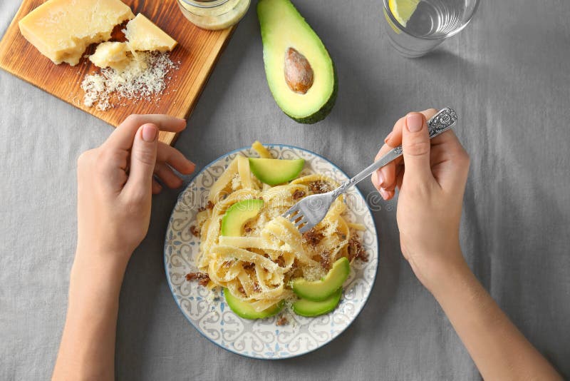 Kvinna som äter läcker pasta med avokadot royaltyfria foton Kvinna som äter läcker pasta med avokadot royaltyfria foton
