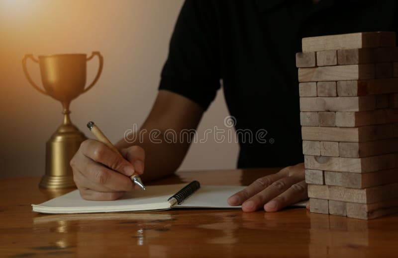 Kvinnaaffärshand som writeing på anmärkningsboken med kvarterträleken på trätabellen royaltyfri fotografi Kvinnaaffärshand som writeing på anmärkningsboken med kvarterträleken på trätabellen royaltyfri fotografi