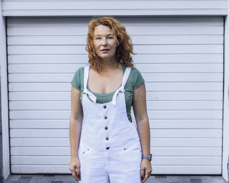 Kvinnaanseende på den vita modellen för minimalism i vita overaller Dag som är utomhus- fotografering för bildbyråer Kvinnaanseende på den vita modellen för minimalism i vita overaller Dag som är utomhus- fotografering för bildbyråer